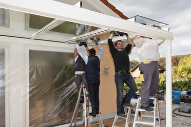 Germany, Rhineland Palatinate, Men assembling glass canopy - CSF018842