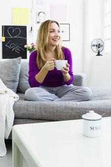 Deutschland, Bayern, München, Junge Frau hält Teetasse, lächelnd - SPOF000271