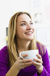 Germany, Bavaria, Munich, Young woman holding tea cup, close up - SPOF000281