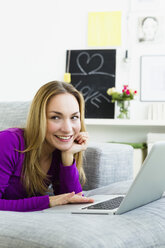 Germany, Bavaria, Munich, Young woman using laptop, smiling - SPOF000283