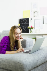 Germany, Bavaria, Munich, Young woman using laptop, smiling - SPOF000336