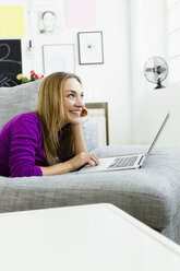 Germany, Bavaria, Munich, Young woman using laptop, smiling - SPOF000337