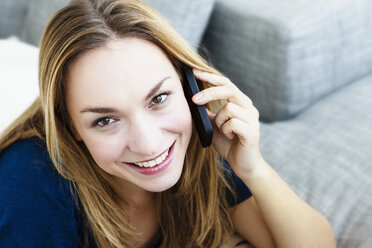 Germany, Bavaria, Munich, Portrait of young woman talking on mobile phone, close up - SPOF000295