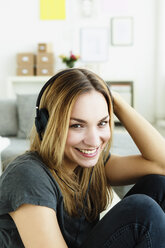 Germany, Bavaria, Munich, Portrait of young woman listening music, smiling - SPOF000312