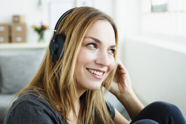 Germany, Bavaria, Munich, Young woman listening music, smiling - SPOF000314