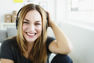 Germany, Bavaria, Munich, Portrait of young woman listening music, smiling - SPOF000316