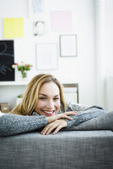 Germany, Bavaria, Munich, Portrait of young woman relaxing on couch, smiling - SPOF000325