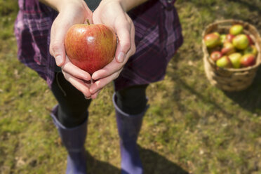 Germany, Teenage girl holding organic apple - ONF000160