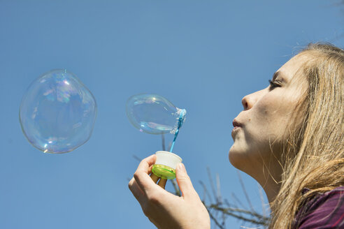 Germany, Teenage girl blowing bubbles - ONF000176