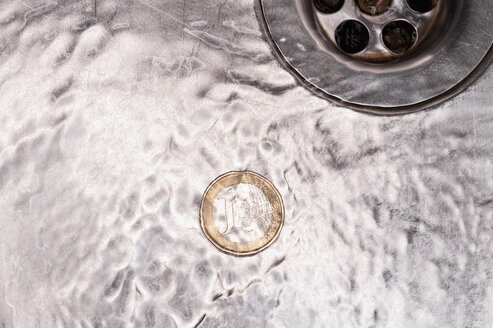 Euro coin in kitchen sink with flowing water, close up - KJF000218