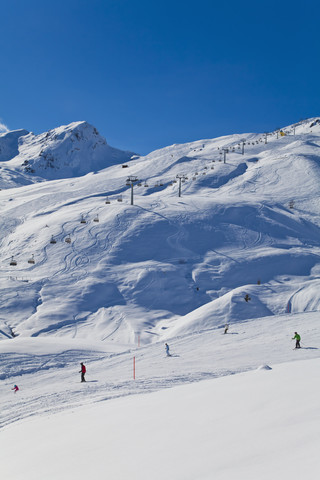 Schweiz, Carmenna, Menschen beim Skifahren im Schnee, Sessellift im Hintergrund, lizenzfreies Stockfoto