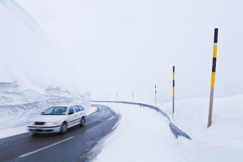 Switzerland, Car passing through snow covered road - WDF001701