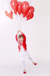 Portrait of girl flying with bunch of balloons, smiling - KFF000002