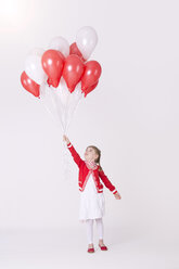 Girl holding bunch of balloons against pink background - KFF000003