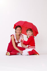 Porträt von Mutter und Tochter unter einem Regenschirm, lächelnd - KFF000005