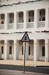 Katar, Doha, Straßenschild auf der Straße mit Gebäude im Hintergrund - FB000029