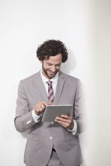 Deutschland, Nordrhein-Westfalen, Köln, Geschäftsmann mit digitalem Tablet, lächelnd - FMKF000841