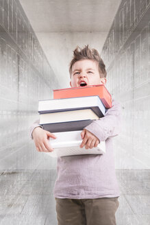 Germany, Brandenburg, Boy holding stack of books - FKF000168