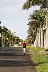 USA, Hawaii, Frau joggt auf der Straße - SKF001271