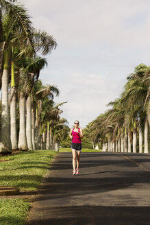 USA, Hawaii, Frau joggt auf der Straße - SKF001272