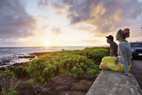 USA, Hawaii, Mid adult couple watching sundown by sea - SKF001275