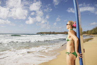 USA, Hawaii, Mittlere erwachsene Frau steht mit Surfbrett am Strand - SKF001277