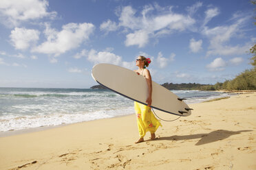 USA, Hawaii, Woman standing with surfboard on beach - SKF001278