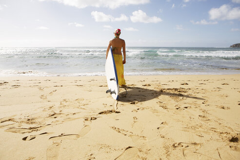 USA, Hawaii, Mittlere erwachsene Frau steht mit Surfbrett am Strand - SKF001279