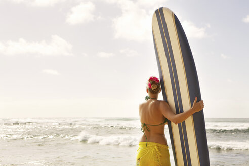 USA, Hawaii, Milde erwachsene Frau stehend mit Surfbrett am Strand - SKF001281