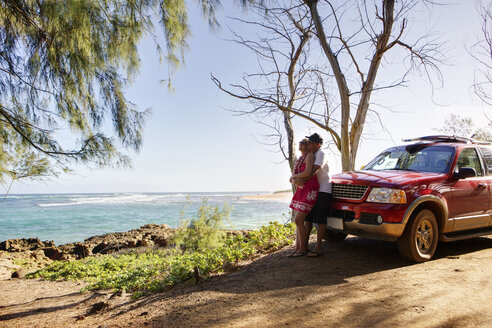 USA, Hawaii, Mid adult couple standing near car - SKF001287