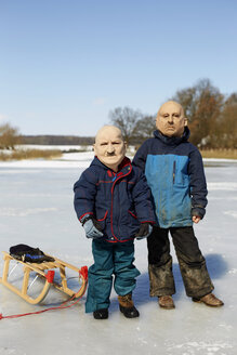 Deutschland, Jungen mit Maske von alten Männern im Winter - TKF000126