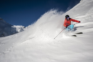 Österreich, Salzburg, Junger Mann beim Skifahren in den Bergen von Altenmarkt Zauchensee - HHF004569