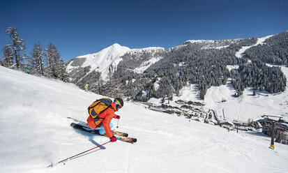 Österreich, Salzburg, Junger Mann beim Skifahren in den Bergen von Altenmarkt Zauchensee - HHF004565
