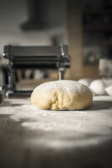 Nudelteig mit Mehl, Nudelmaschine und Ei im Hintergrund - SBD000056