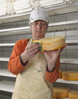 Deutschland, Baden Württemberg, Reife Frau bereitet Käse in der Industrie vor - LA000026