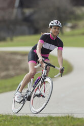 Germany, Bavaria, Mid adult woman riding roadbike - FF001344