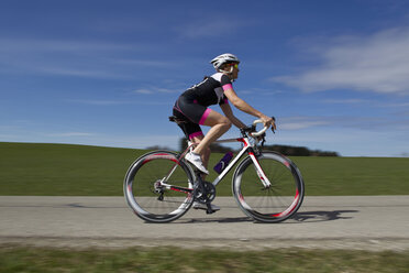 Germany, Bavaria, Mid adult woman riding roadbike - FF001338