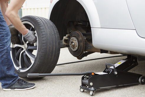 Germany, Bavaria, Kaufbeuren, Mature man changing car tire - DSCF000063