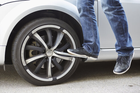 Germany, Bavaria, Kaufbeuren, Mature man changing car tire - DSCF000066