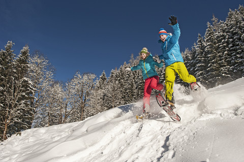 Österreich, Salzburg, Junge Frau und Mann beim Schneeschuhwandern in Altenmarkt Zauchensee, lizenzfreies Stockfoto