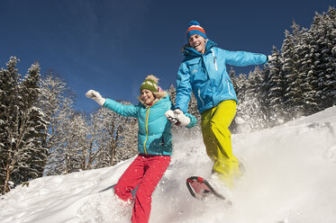 Austria, Salzburg, Young woman and man snowshoeing at Altenmarkt Zauchensee - HHF004579