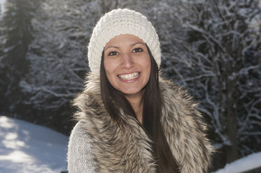 Österreich, Salzburg, Porträt einer jungen Frau im Schnee, lächelnd - HHF004554