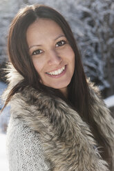 Österreich, Salzburg, Porträt einer jungen Frau im Schnee, lächelnd - HHF004562