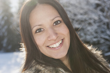 Austria, Salzburg, Portrait of young woman in snow, smiling - HHF004561