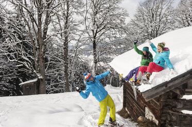 Österreich, Salzburg, Junge Frauen und Mann haben Spaß im Schnee in Altenmarkt Zauchensee - HHF004559