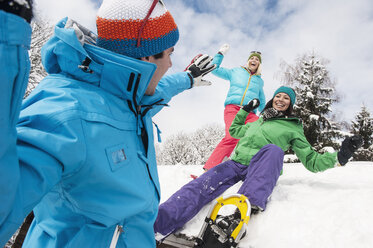 Österreich, Salzburg, Junge Frauen und Mann haben Spaß im Schnee in Altenmarkt Zauchensee - HHF004558