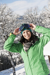 Österreich, Salzburg, Porträt einer jungen Frau im Schnee, lächelnd - HHF004556