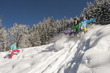 Austria, Salzburg, Young man and women with sledge in snow at Altenmarkt Zauchensee - HHF004585