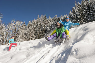 Österreich, Salzburg, Junger Mann und Frau mit Schlitten im Schnee in Altenmarkt Zauchensee - HHF004584