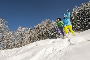 Austria, Salzburg, Young woman and man snowshoeing at Altenmarkt Zauchensee - HHF004583